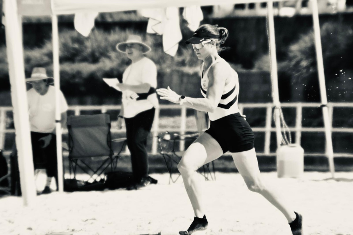 Erin James sprinting up the beach in West End colours