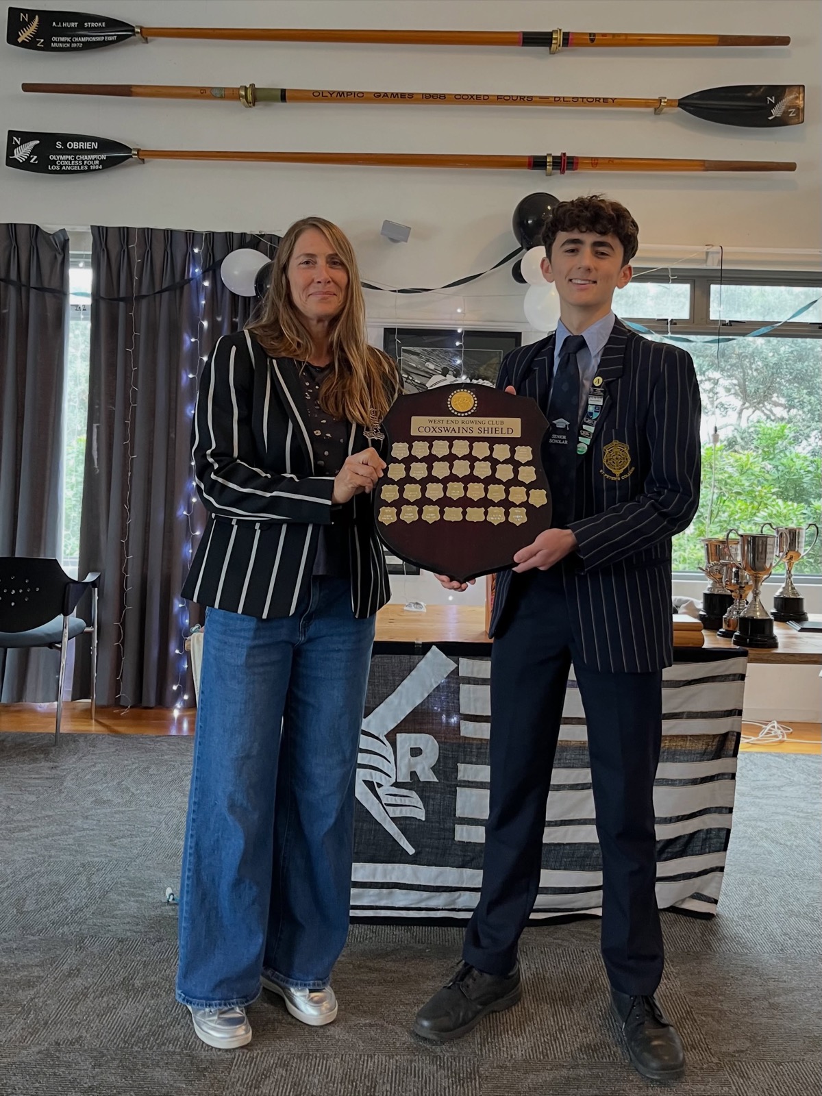 School rower receiving a trophy shield at prizegiving